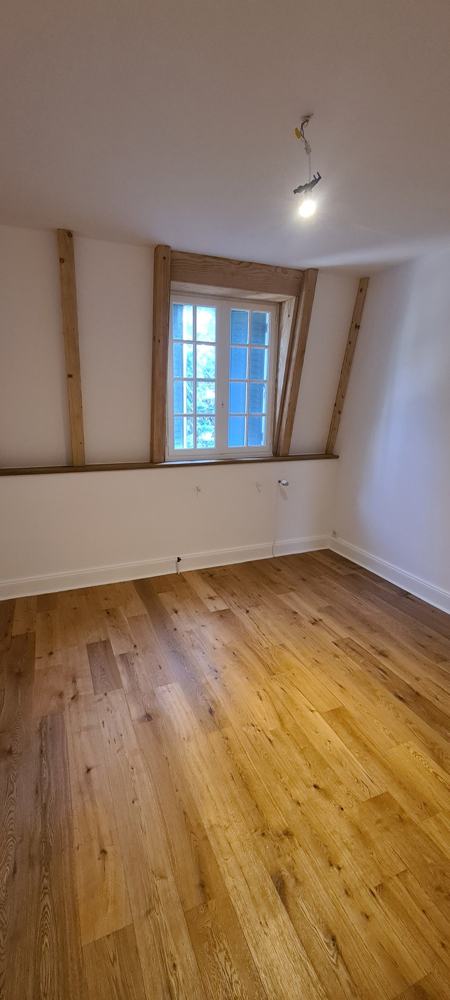 Pièce rénovée, parquet et poutres conservées, chantier ESSIO Solution